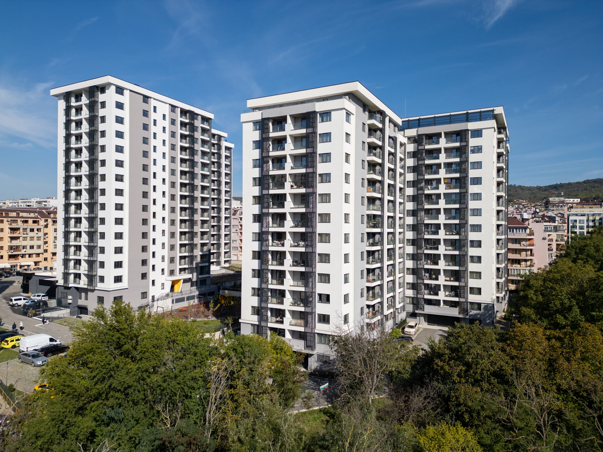 Aerial view of modern residential high-rise buildings with balconies and outdoor areas. The clean, geometric design of the apartments highlights contemporary urban living. Shot with a drone Aerial view of modern residential high-rise buildings with balconies and outdoor areas. The clean, geometric design of the apartments highlights contemporary urban living. Shot with a drone.